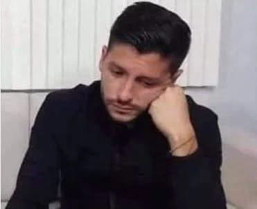 Manuel Natal Albelo, candidato derrotado dos veces a la alcaldía de San Juan, sentado con la cabeza apoyada en su mano izquierda, en la que lleva una pulsera, vestido con chaqueta y camisa negras, con la mirada hacia abajo y expresión seria, frente a una pared con paneles verticales blancos.